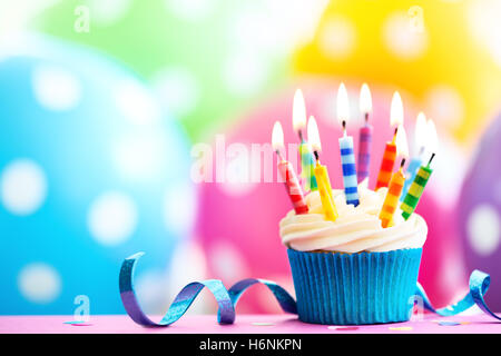 Cupcake decorated with colorful birthday candles Stock Photo