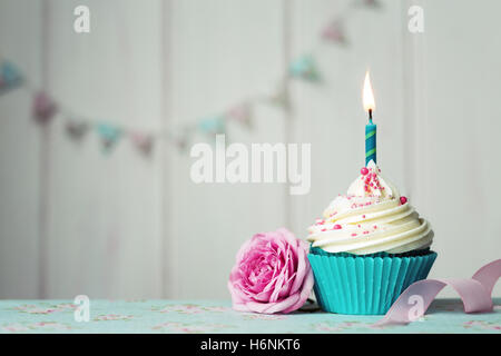 Cupcake with single candle and pink rose Stock Photo