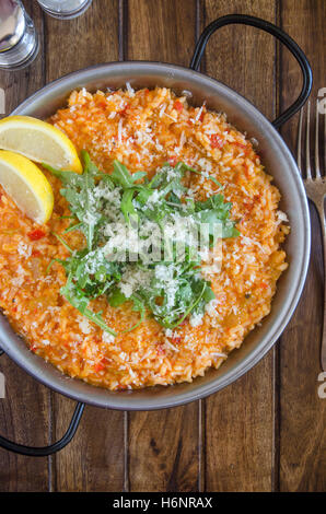 Red pepper risotto with Parmesan and rocket Stock Photo
