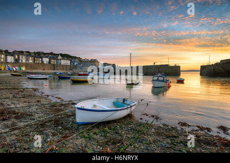 Beautiful sunrise over fishing boats in the harbour at Mousehole near Penzance in Cornwall Stock Photo