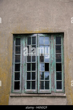 Vintage wooden window frame with broken glass looking through a green ...