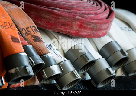 Fire hose lined up in a rack in a fire station Stock Photo