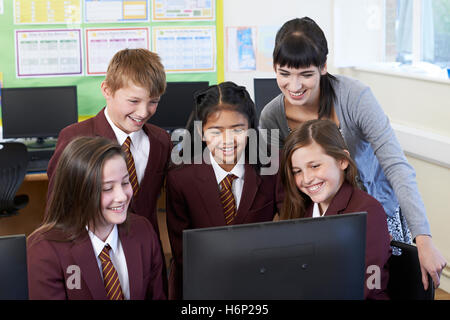 Elementary School Pupils With Teacher In Computer Class Stock Photo