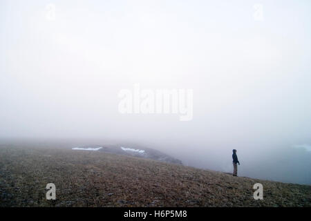 woman walk go going walking female winter male masculine cloud snow coke cocaine material drug anaesthetic addictive drug fog Stock Photo