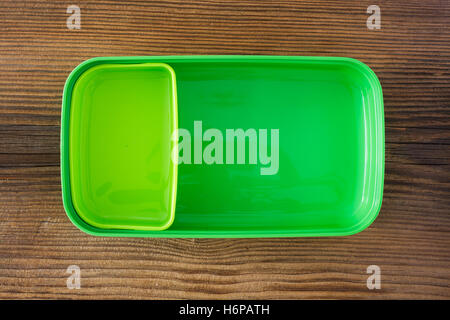 Green plastic lunch box on wooden background Stock Photo