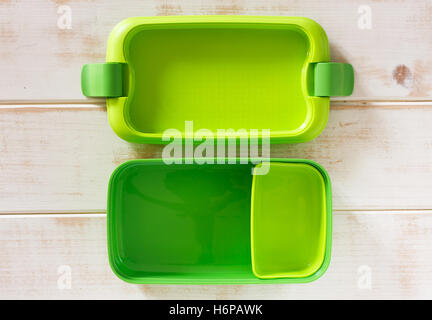 Green plastic lunch box on wooden background Stock Photo