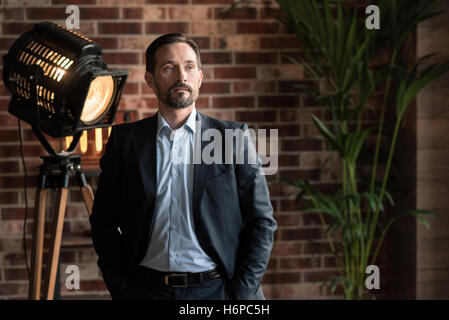 Successful confident man putting hands in his pockets Stock Photo