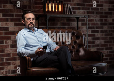 Good looking nice businessman holding a mobile phone Stock Photo