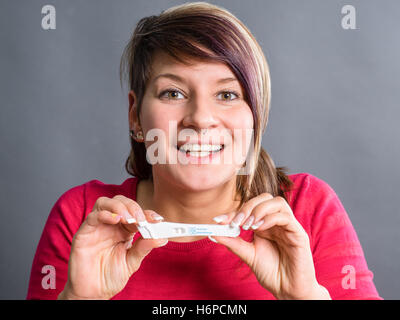 Pregnancy test - happy surprised woman Stock Photo