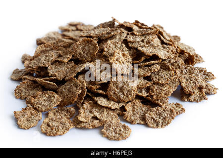 Close up detail of a pile of wheat bran breakfast cereal flakes as a background in pespective. Isolated on white. Stock Photo