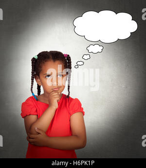Doubtful little girl with a blank bubble on a over gray background Stock Photo