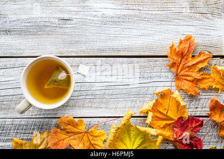 yellow autumn leaves Tea Cup on a red background Stock Photo - Alamy