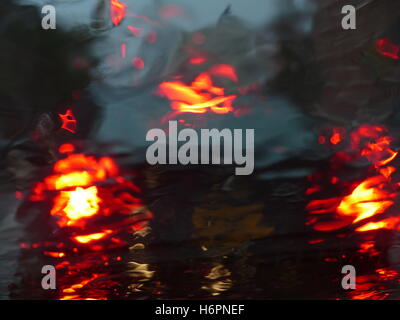 View of car brake lights through wet windshield Stock Photo