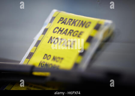 Parking charge notice stuck onto windscreen of a car Stock Photo