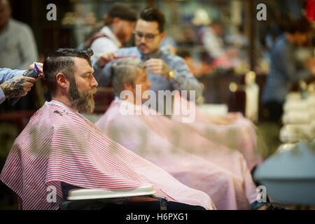 Gents barber hairdresser grooming male   busy street  Shops shopping shopper store retail retailer retail retailers traders trad Stock Photo