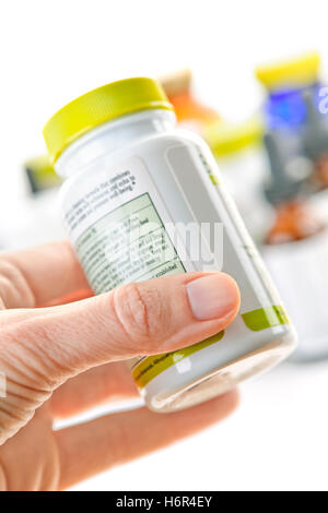 hand health bottle drugs means agent medicine drug remedy substance medicin reading label possession holding close some several Stock Photo