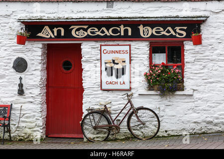 Old bicycle and Guinnes advertising outside An Teach Beag, the little house, pub in Union Hall, glandore, County Cork, Ireland Stock Photo