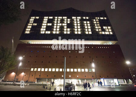 Hamburg, Germany. 31st Oct, 2016. The word 'Fertig' (lit. 'Done') can be seen on the facade via lights in specific windows of the Elbphilharmonie in Hamburg, Germany, 31 October 2016. The construction of the Elbphilharmonie in Hamburg is completed - roughly nine years after the laying of the foundation stone. The construction group Hochtief officially handed over the concert house to the city. It is said to open on 11 January 2017. PHOTO: CHRISTIAN CHARISIUS/dpa/Alamy Live News Stock Photo