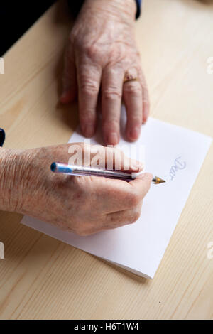 woman note memo hand hands write wrote writing writes greeting female written dear letter old elderly sheet of paper paper give Stock Photo