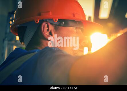Construction Worker in the Sun. Caucasian Worker in His 30s Wearing Red Safety Helmet. Stock Photo