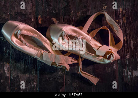 Ballet pointe shoes lie on the wooden floor of the stage in the theater before start the performance Stock Photo