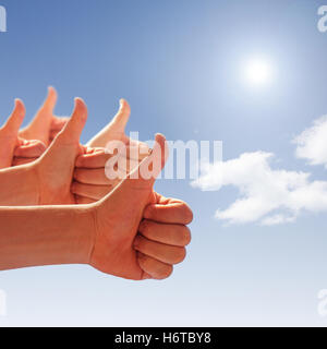 men hands showing thumbs up on blue sky Stock Photo
