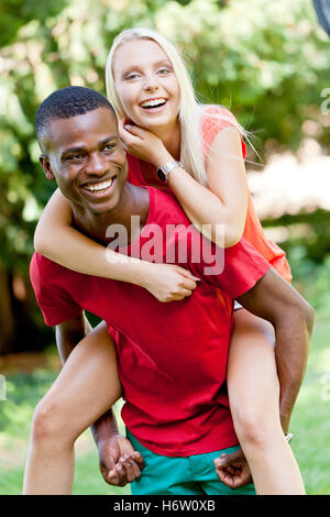 young enamored multicultural couple in a meadow Stock Photo