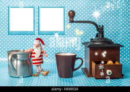 Cute Christmas card with two empty photo frames, Santa toy and cup of coffee on polka dots background Stock Photo
