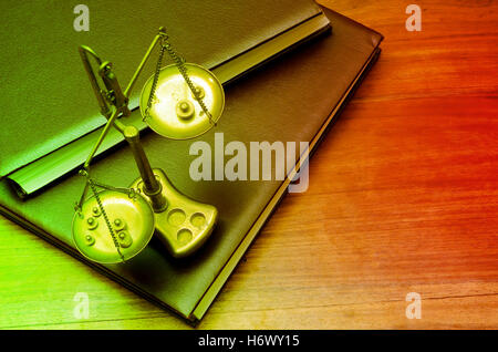 Mechanical golden weight scale, also laboratory balance, balance scale, or beam balance on law books Stock Photo