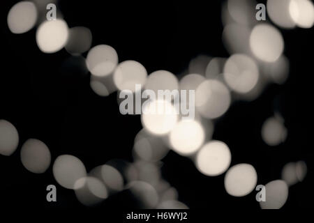 De-focused lights in the dark. Blurred spots of decoration bokeh shot. Vintage rich black and creamy white Stock Photo