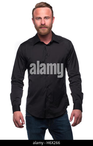 Wealthy confident relaxed young man in black shirt and denim jeans looking at camera isolated over white studio background Stock Photo