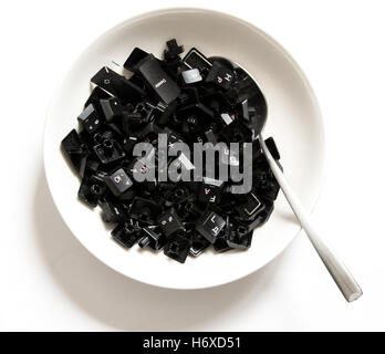 Keyboard keys in a dish with a spoon Stock Photo