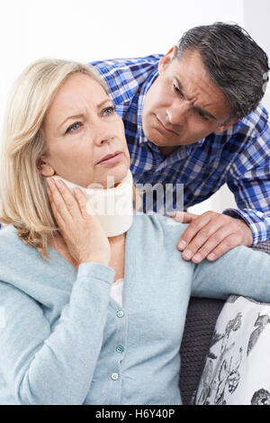 Husband Comforting Husband Suffering With Neck Injury Stock Photo