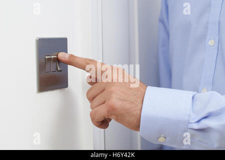 Close Up Of Man Turning Off Light Switch Stock Photo