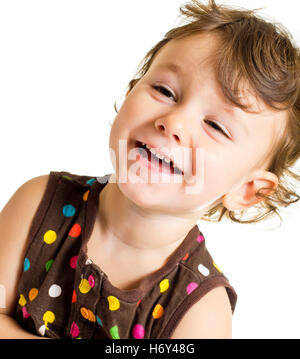 Three years old smiling little girl in brown polka-dot dress. Stock Photo