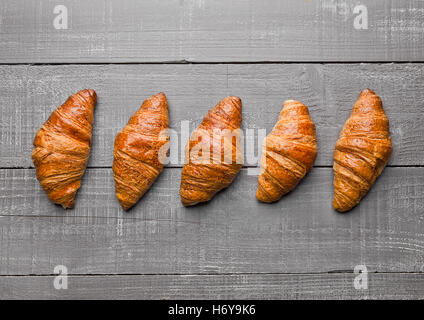 Fresh crispy croissant for breakfast on wooden background Stock Photo