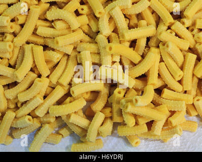 Homemade macaroni yellow dry pasta in the shape of little tubes Stock Photo
