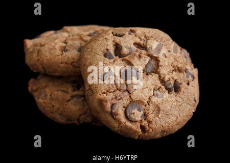 Three chocolate chip cookies isolated on black. Stock Photo