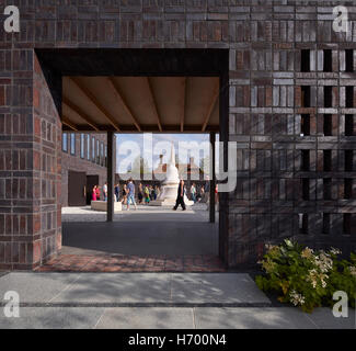 Multi-toned brickwork framing view towards Stupa during ceremony. Vajrasana Retreat, Walsham-le-Willows, United Kingdom. Architect: Walters and Cohen Ltd, 2016. Stock Photo