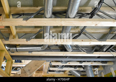 Interior of new UK energy efficient Passive House showing building materials & ventilation trunking installed within lattice ceiling beams Stock Photo