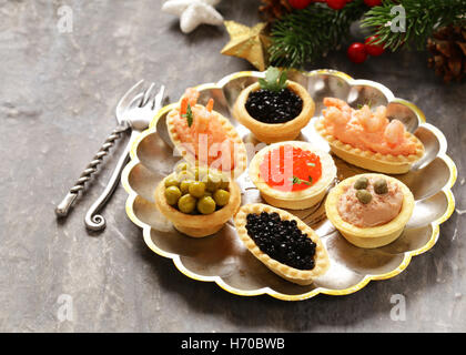 Christmas appetizers. Small tartlets with caviar and pate. Buffet and bar. Stock Photo