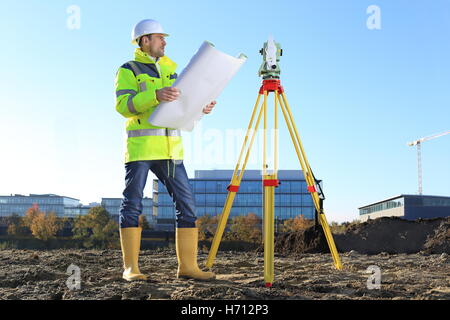 A Surveyor on a hill holding a Plan roll in hands Stock Photo