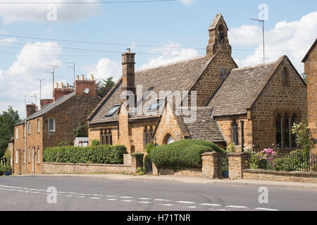 A restored Almshouse alongside other properties in the village of Adderbury, North Oxfordshire, England, UK Stock Photo