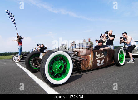 Starter girl starting a hot rod race, while photographers taking their pictures. Hot Rods, Kustoms, Cruisers & Art at the Stock Photo