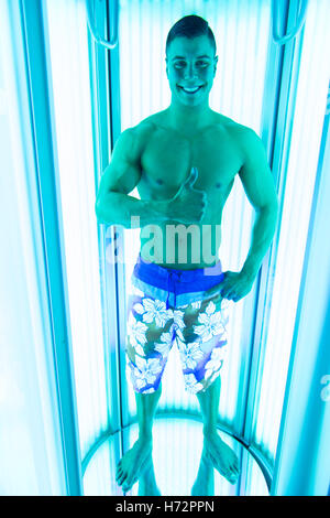 Young Muscular Man At Solarium In Beauty Salon Stock Photo