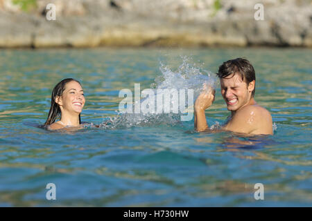 Couple playing bathing on the beach in summer vacation Stock Photo