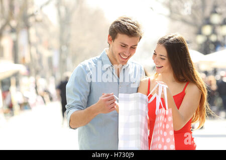 Couple shopping and holding bags in the street Stock Photo