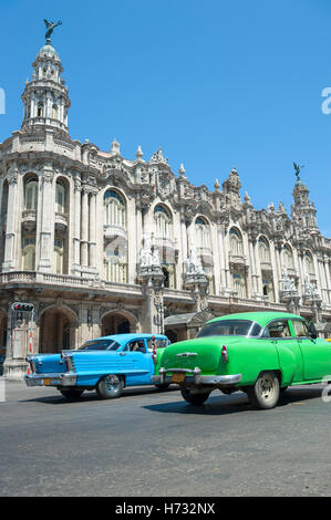 HAVANA, CUBA - JUNE 13, 2011: Brightly colored vintage American cars pass in front of the Great Theater of Havana. Stock Photo