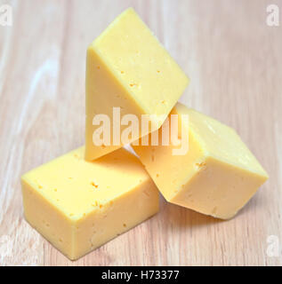 pieces of cheese on wooden board Stock Photo