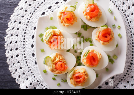 Eggs stuffed with salmon, cheese and cucumber closeup on a table. Horizontal view from above Stock Photo